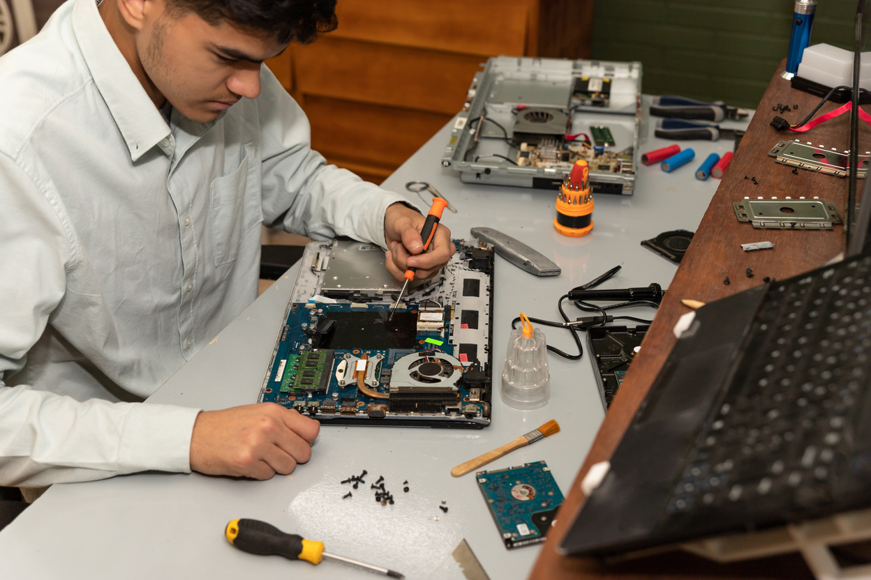 Computer repair technician repairing a laptop