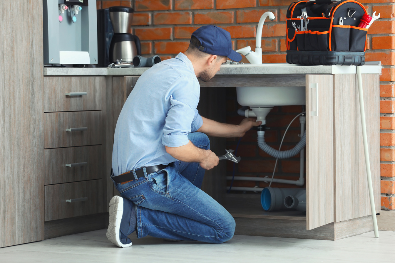 Professional Plumber Fixing Kitchen Sink